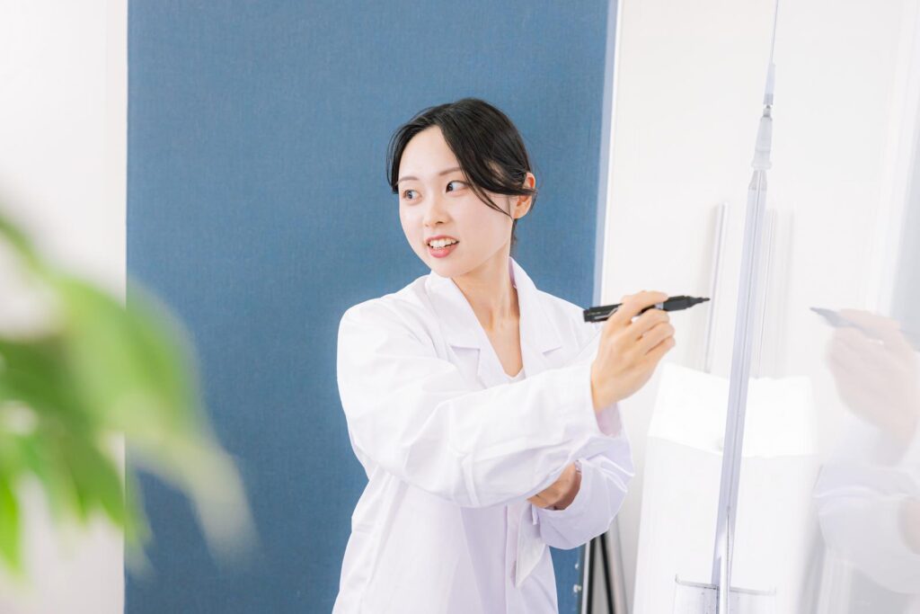 ホワイトボードに書きながら説明をする女医