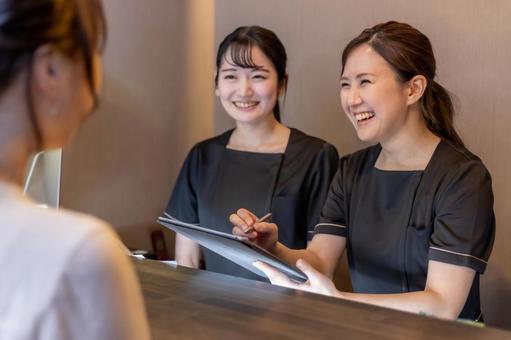 受付でお客様と話す女性2人