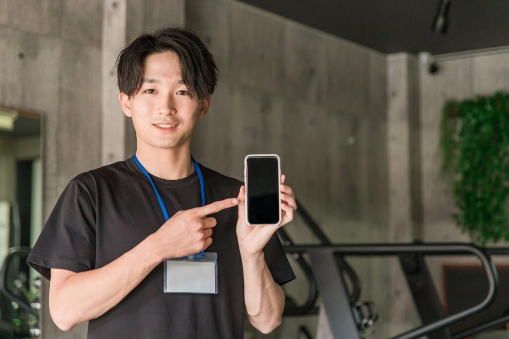 スマホを指さす男性