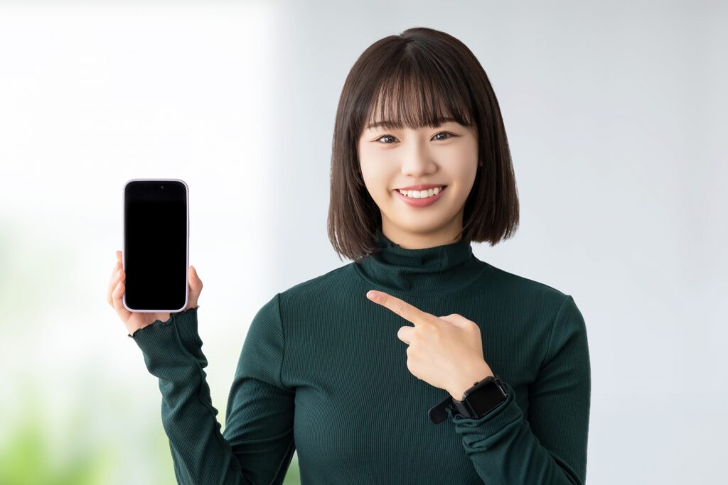 スマホを指さすショートカットの女性